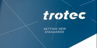 Trotec laser engraved sign with company logo and slogan on blue acrylic surface