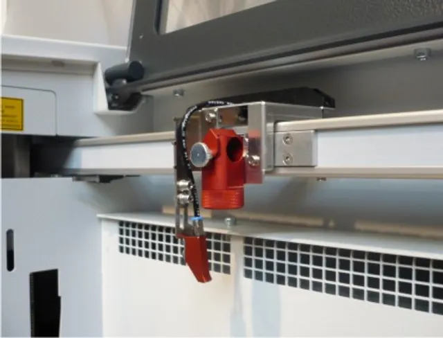 Trotec laser cutting head on gantry rail inside Speedy series CO₂ laser engraving machine