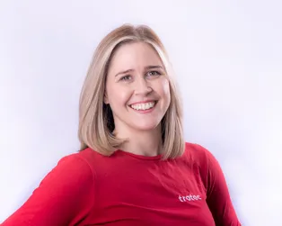 Smiling woman in red Trotec shirt representing laser engraving technology team