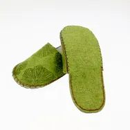 Chaussons en feutre avec motif floral créé à l'aide de la machine de découpe laser Trotec sur un textile vert.