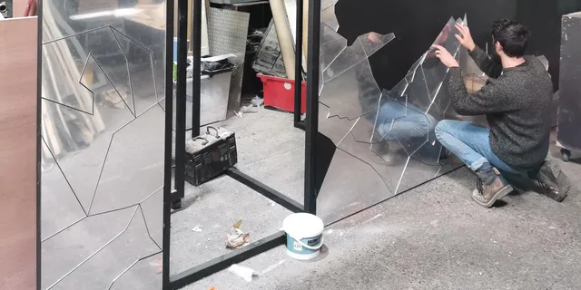 Techniker, der lasergeschnittene Acrylplatten für eine dekorative Installation an der Wand anbringt