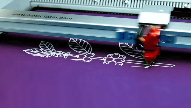 Trotec Laserschneider graviert detailliertes Blumendesign auf lila Material
