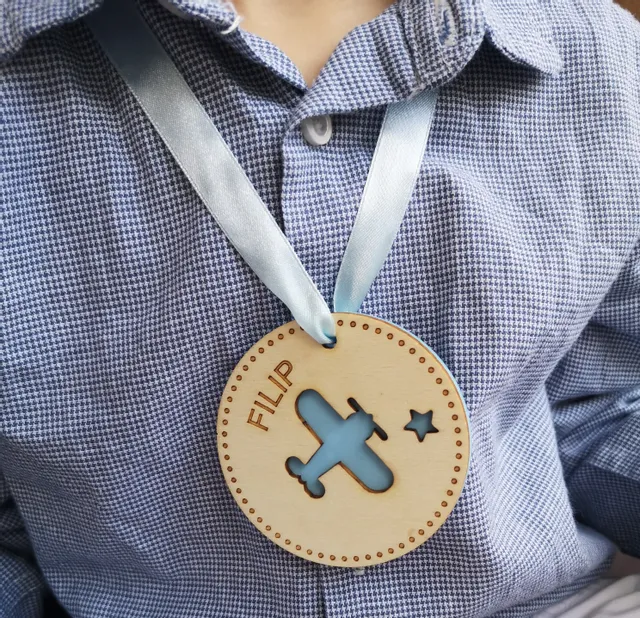Niestandardowy drewniany medal z wyciętym samolotem wygrawerowany za pomocą wycinarki laserowej Trotec.