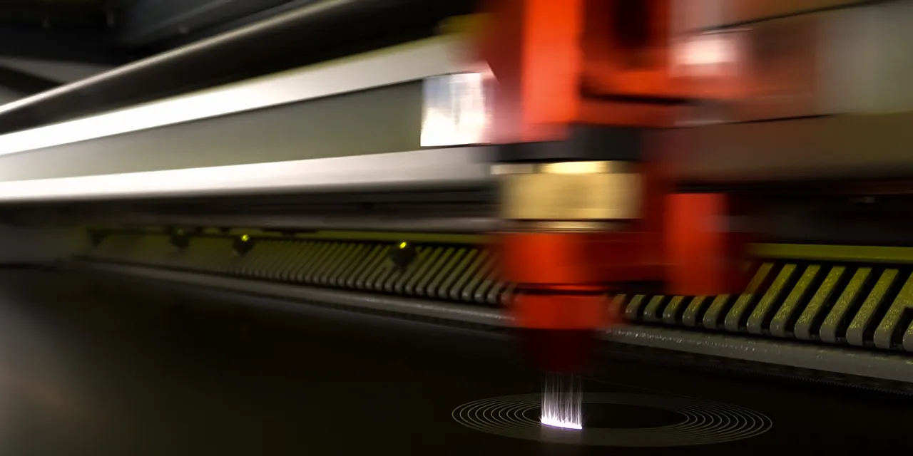 Trotec CO₂ laser cutter engraving precision circular pattern on dark material