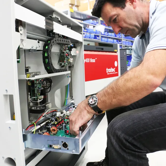Trotec Speedy 400 flexx lazer kazıma makinesinin dahili bileşenlerine bakım yapan teknisyen