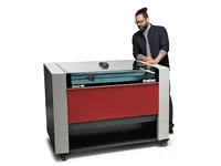 Operario utilizando una máquina de corte láser de CO₂ Trotec Speedy 400 para realizar grabados de precisión