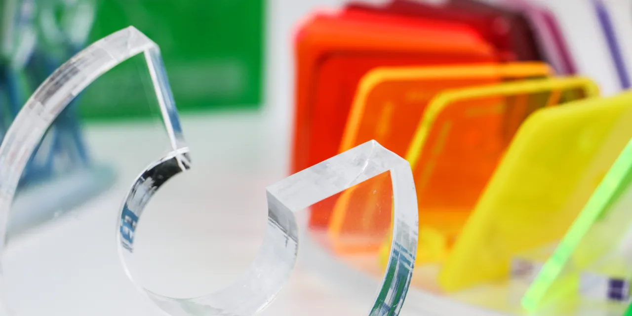 Colorful acrylic samples and precision-cut clear acrylic shape made with Trotec laser cutter