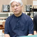 近代的なワークショップでレーザー彫刻機の前に座る男性。