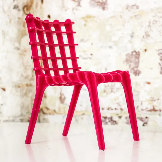 Miniature red chair made with Trotec laser cutter from interlocking acrylic parts