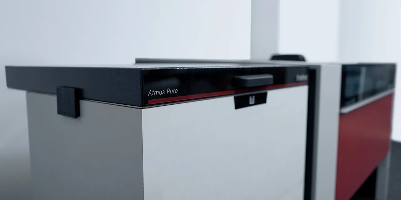Trotec Atmos Pure Absauganlage neben dem Laserschneider der Speedy-Serie