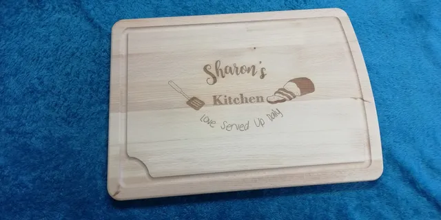 Wooden cutting board engraved with 'Sharon's Kitchen' using Trotec CO₂ laser engraving machine