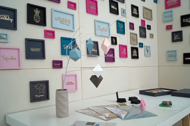 Wall display of Trotec laser-cut wooden signs and paper art decorations