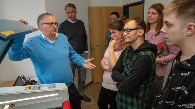 Instructor demonstrating Trotec laser cutter to group of students during training session
