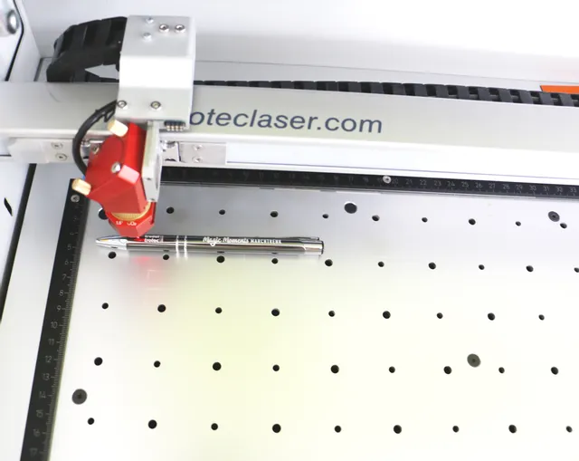 Trotec laser engraving pen with Speedy series CO₂ laser cutter on aluminum grid table