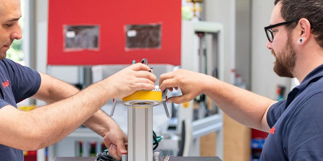 Trotec technicians assembling component for laser engraving machine in manufacturing facility
