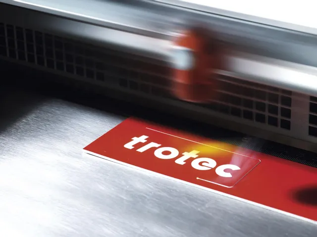 赤い二層板看板材料をカットするトロテック・レーザー彫刻機