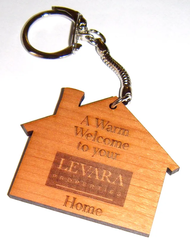 Wooden house-shaped keychain laser engraved with Levara Properties logo using Trotec CO₂ laser