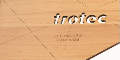 Präzises Trotec CO₂ Lasergravieren und -schneiden von Logo und Text auf Holzoberflächen