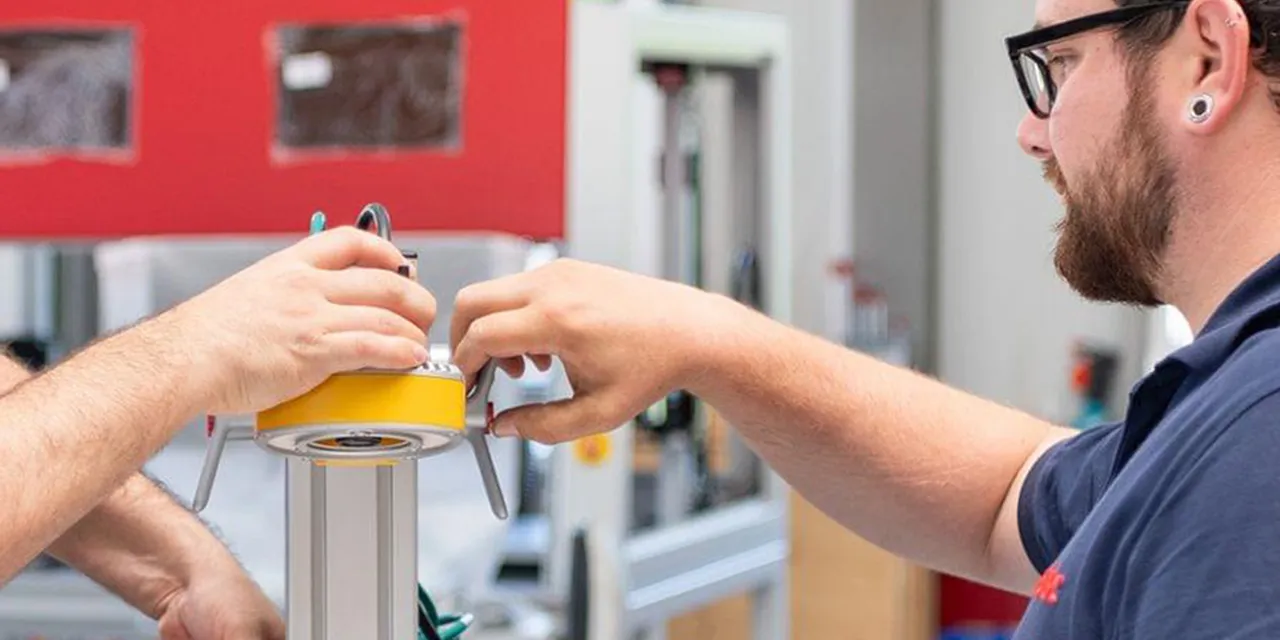 Trotec-technici assembleren onderdelen voor lasergraveermachine in productiefaciliteit