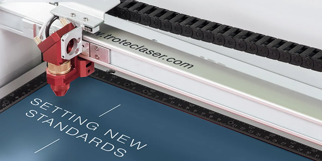 Trotec Speedy Lasergravierer-Kopf ätzt Text auf blauem Material