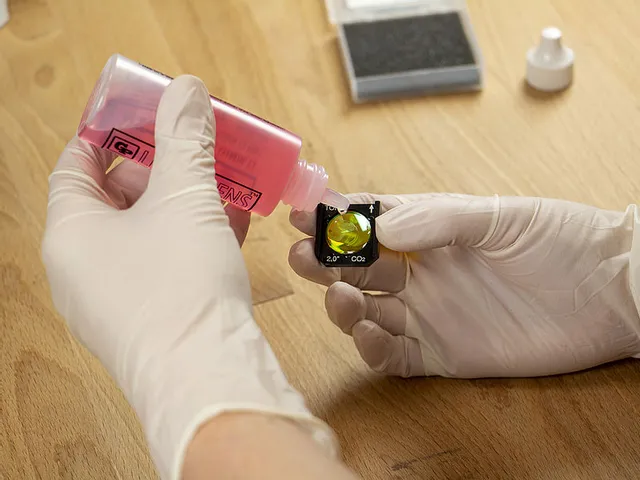 Teknisi membersihkan lensa laser Trotec CO₂ dengan solusi untuk kinerja pemotong laser yang optimal