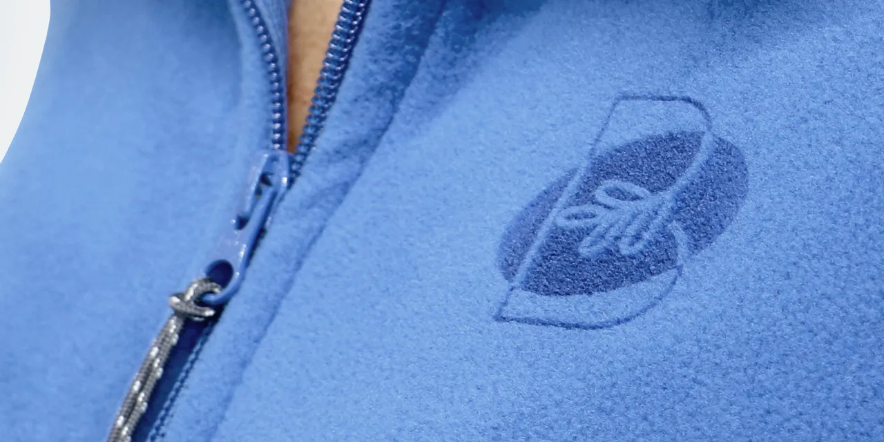Logotipo gravado a laser na jaqueta de lã azul usando a tecnologia a laser Trotec CO₂
