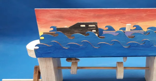 Automate en bois découpé au laser avec des vagues et un bateau peints, probablement créé à l'aide de la machine de découpe laser Trotec CO₂.