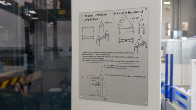 Plaque d'instruction dans la machine de découpe laser Trotec montrant l'installation de levage avec un ou deux palans