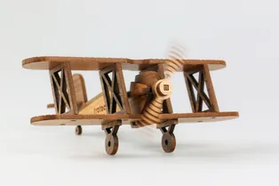 Wooden biplane model cut with Trotec laser cutter showing fine detail and moving propeller