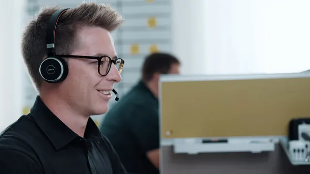 Trotec support representative using headset at customer service workstation