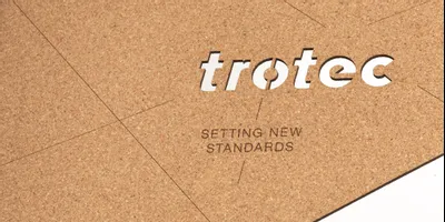 Trotec laser-cut cork sheet with engraved slogan 'Setting New Standards'