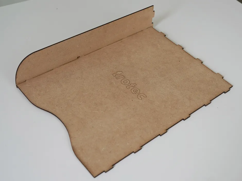 Laser-cut MDF panel with Trotec logo engraved using CO₂ laser cutter