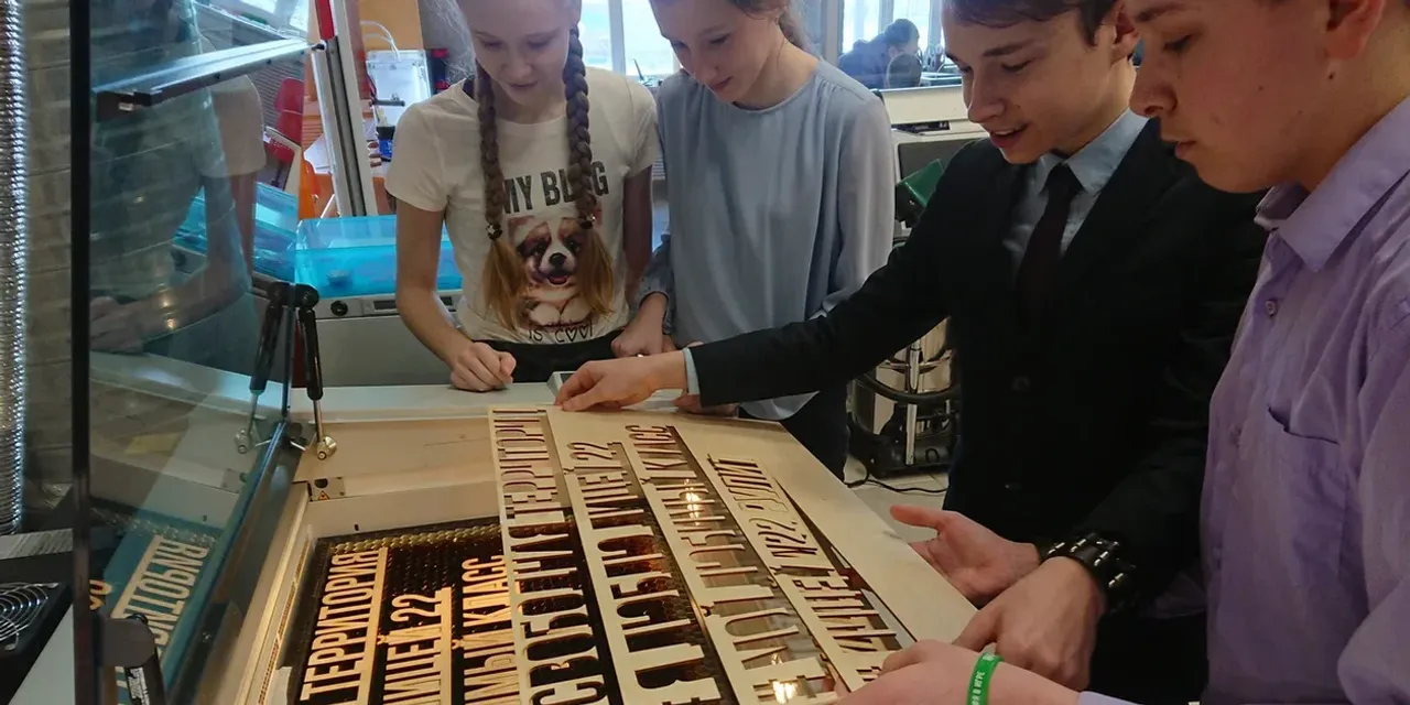 Students using Trotec Speedy series laser cutter to create wooden text stencils