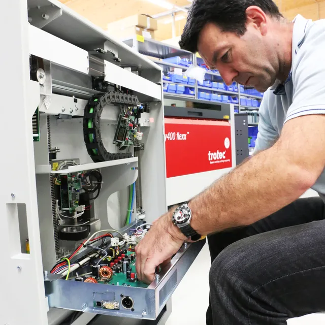 Técnico revisando los componentes internos del grabador láser Trotec Speedy 400 flexx