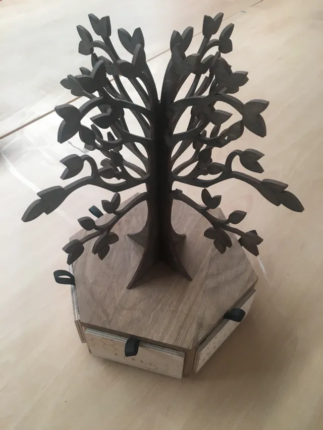 Laser-cut wooden tree on hexagonal base with drawers, crafted using Trotec CO₂ laser cutter
