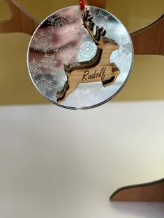 Ornamento in legno tagliato al laser con renna Rudolf e disegno di fiocco di neve su acrilico specchiato, realizzato con il laser Trotec.