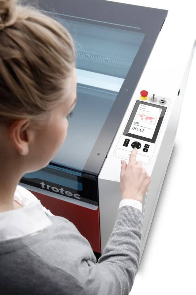 User operating Trotec Speedy series laser cutter with Ruby software interface