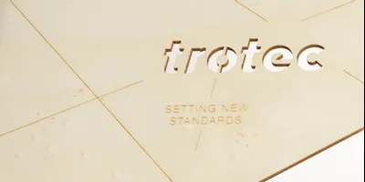 Trotec laser-cut wood sample with engraved slogan using CO₂ laser technology