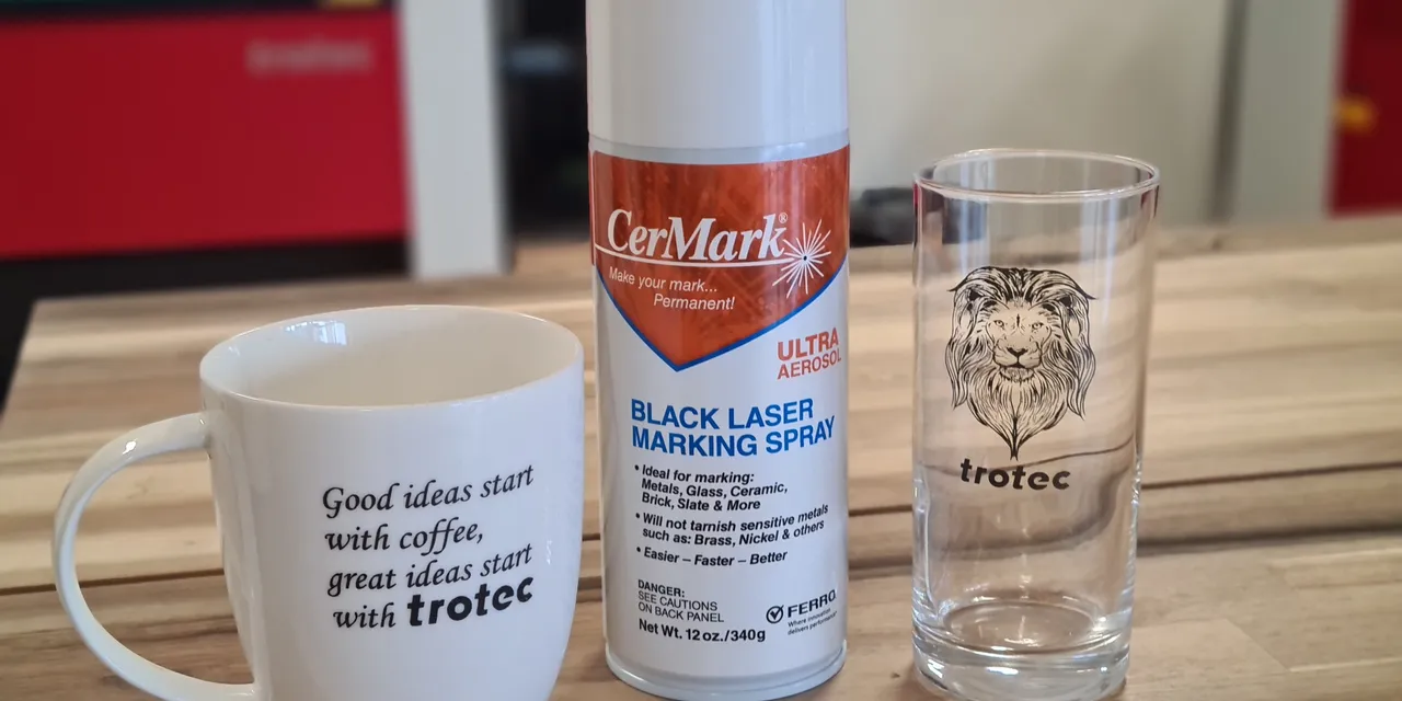 Spray de marquage laser CerMark avec mug et verre gravés par Trotec sur une table en bois