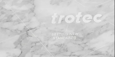 Trotec laser engraving on marble with branding and slogan 'Setting New Standards'