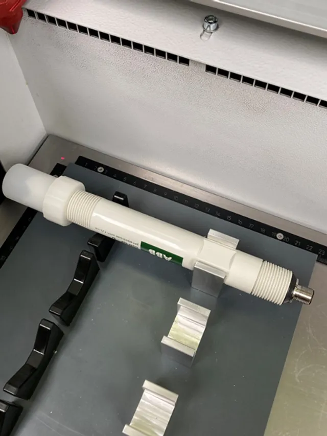 Le SpeedMarker de Trotec marque au laser un composant industriel cylindrique dans une fixation métallique.