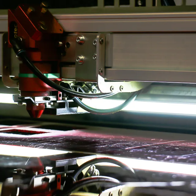 Close-up van Trotec CO₂ lasersnijkop graveert materiaal met precisie