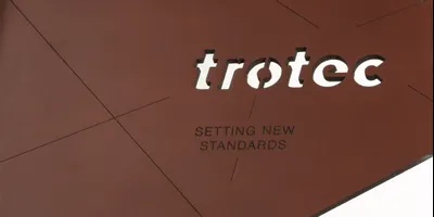 Échantillon de cuir découpé au laser par Trotec, gravé avec le logo et le slogan Setting New Standards (créer nouvelles références)