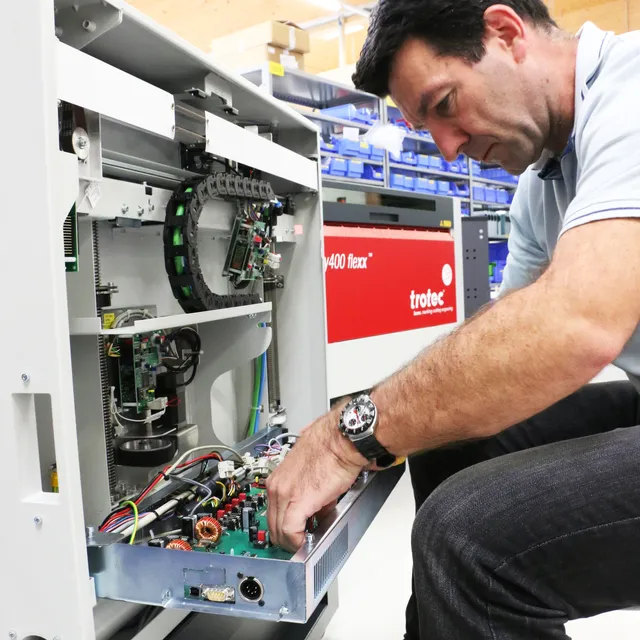 Technicus onderhoudt interne onderdelen van Trotec Speedy 400 flexx lasergraveermachine