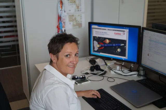 Mujer en el escritorio viendo la interfaz del software de grabado por láser Trotec en el monitor del ordenador
