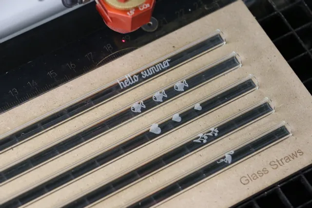 Trotec CO₂ machine de gravure laser marquant des dessins sur des pailles en verre réutilisables.