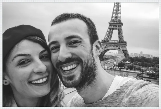 Lächelndes Paar beim Selfie mit dem Eiffelturm im Hintergrund in Paris