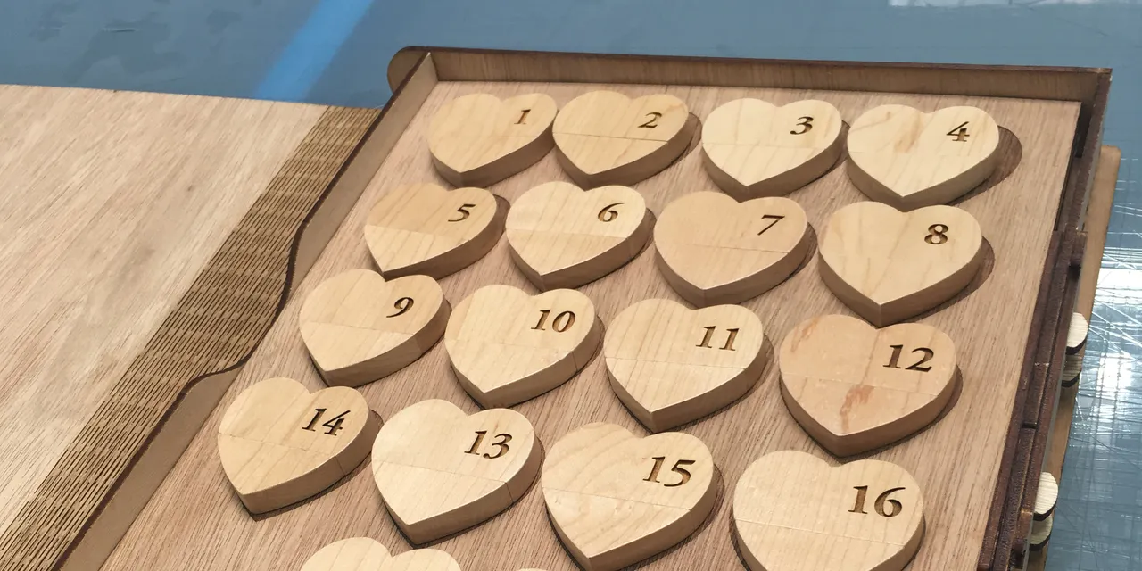 Wooden heart-shaped pieces numbered 1 to 18 cut with Trotec laser cutter on oak board