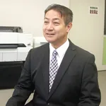 トロテック・レーザーカット技術とは関係のない、プリンターを背にしたビジネスマン。