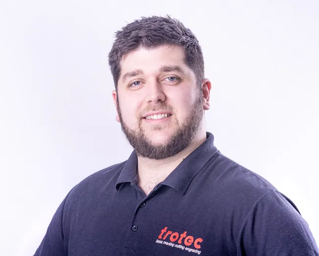 Trotec team member wearing branded polo shirt for laser marking cutting engraving